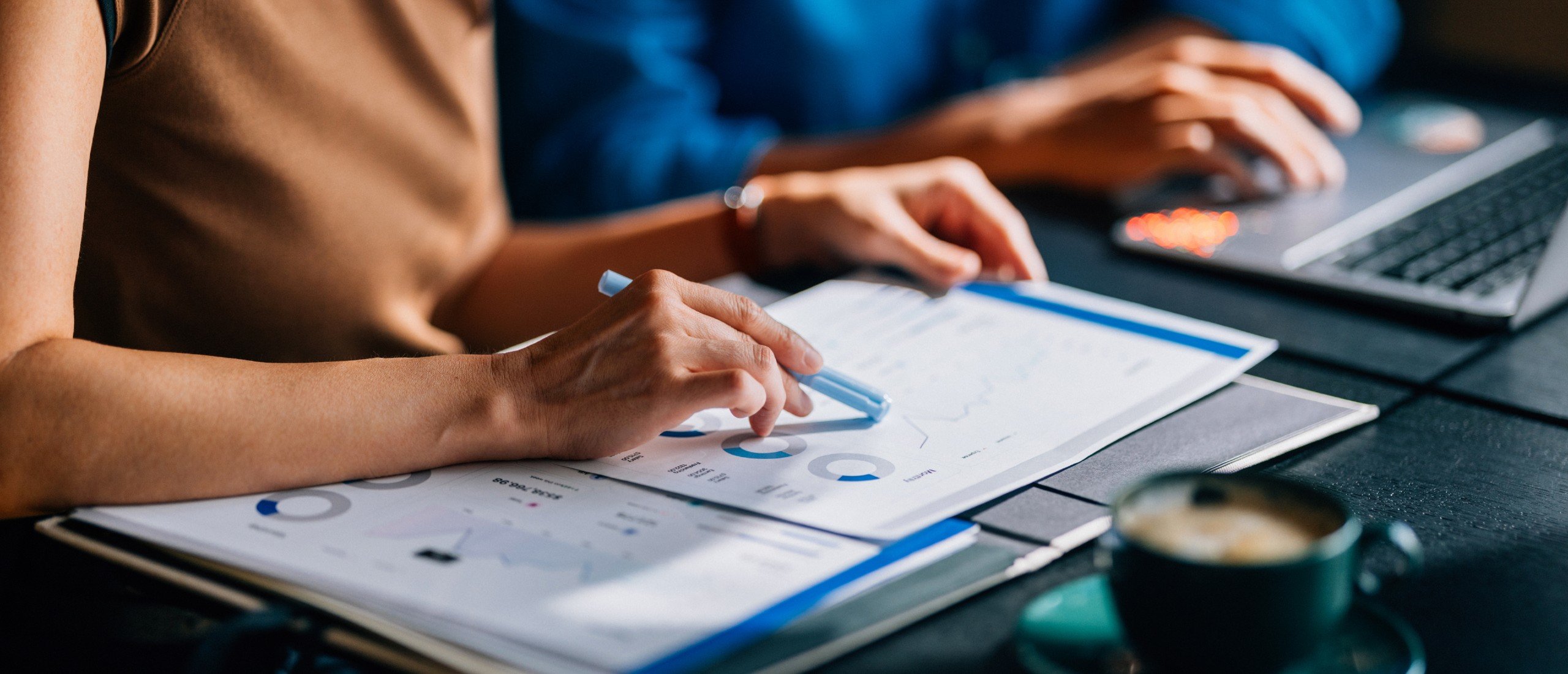Two colleagues reviewing financial data and charts.