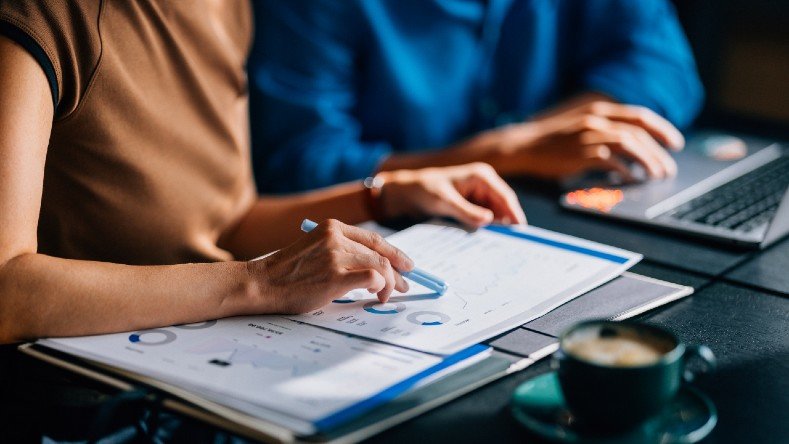 Two colleagues reviewing financial data and charts.