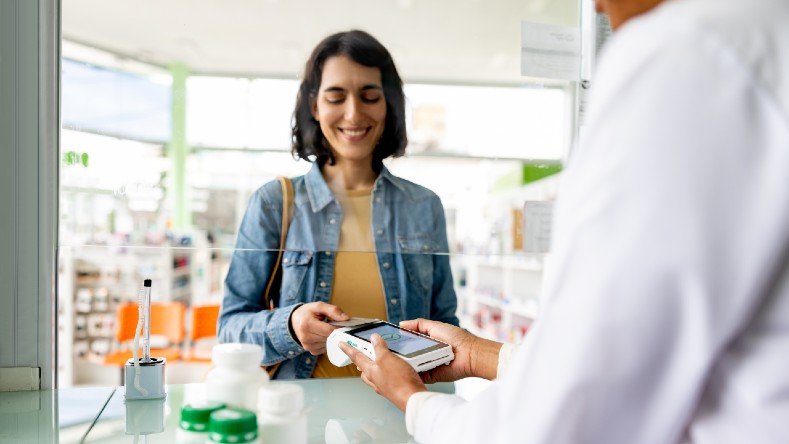 A woman pays for her prescriptions.