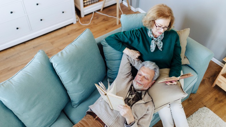 A senior couple relaxes on the couch